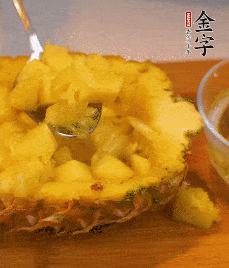 菠蘿對(duì)半切開(kāi)，切成小方格，用勺子把菠蘿肉挖出來(lái)。用鹽水稍浸泡。