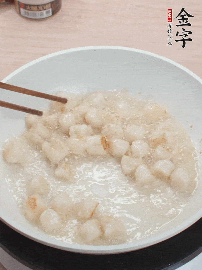 油溫4成熱，鮮貝蘸干淀粉下鍋煎，一面微黃后翻面。
