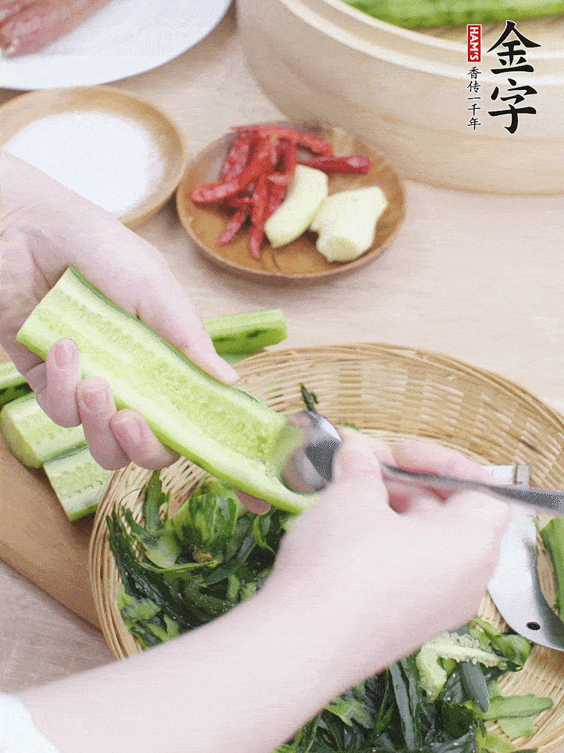 黃瓜削皮，對(duì)半切開(kāi)，勺子挖去內(nèi)瓤，斜刀切片。青蒜斜刀切段。