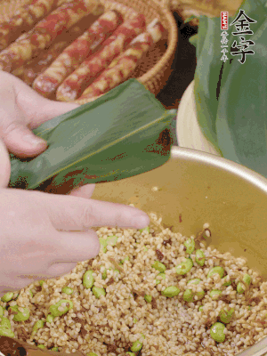 粽葉往下折，完全蓋住，兩側(cè)捏緊。