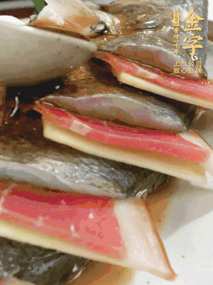 魚肚中塞蔥結(jié)、火腿片，魚身上碼放姜片、火腿片，倒入混合的料汁。