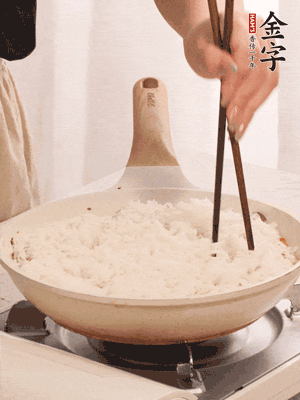 把瀝干水分的米飯均勻鋪在上面，筷子戳幾個洞，以便透氣，轉(zhuǎn)小火蓋上蓋子燜至水分收干，大概10分鐘。