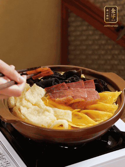 砂鍋底部鋪上娃娃菜，依次擺上肉皮、蛋餃、黑木耳、火腿